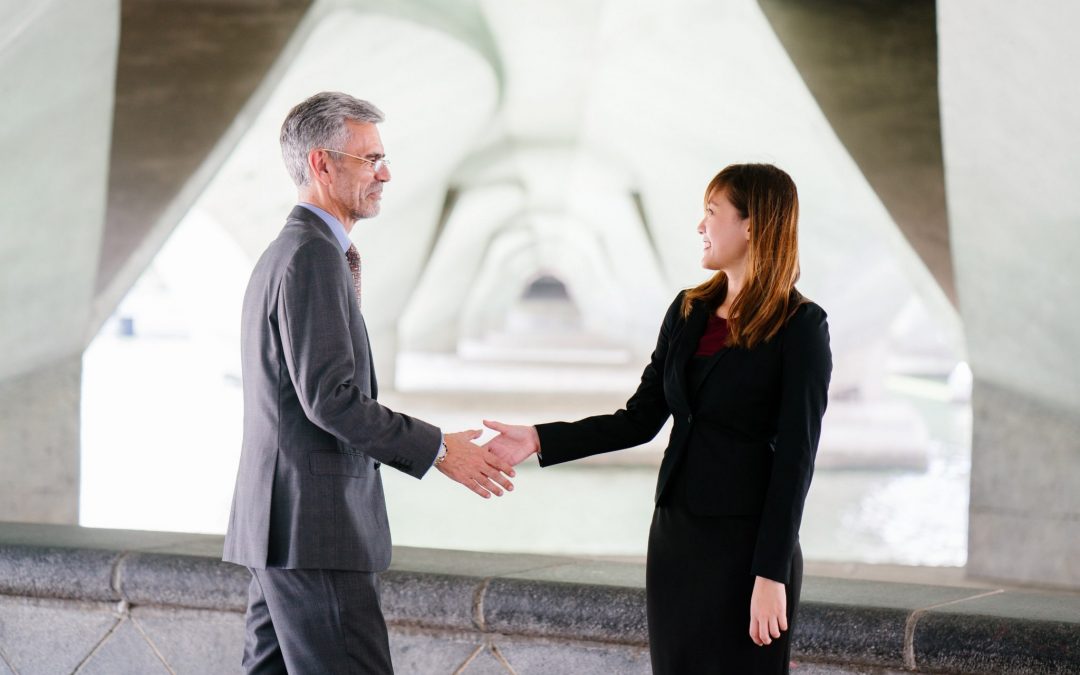 man and woman shaking hands outside