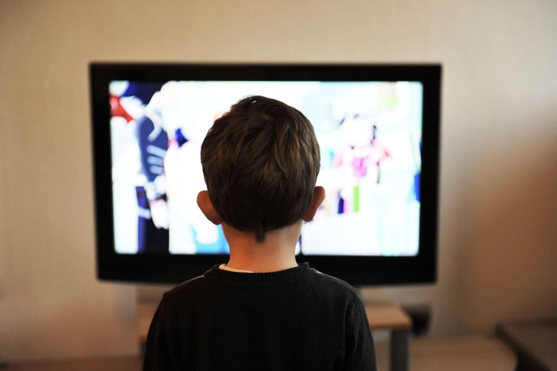 child in front of tv screen