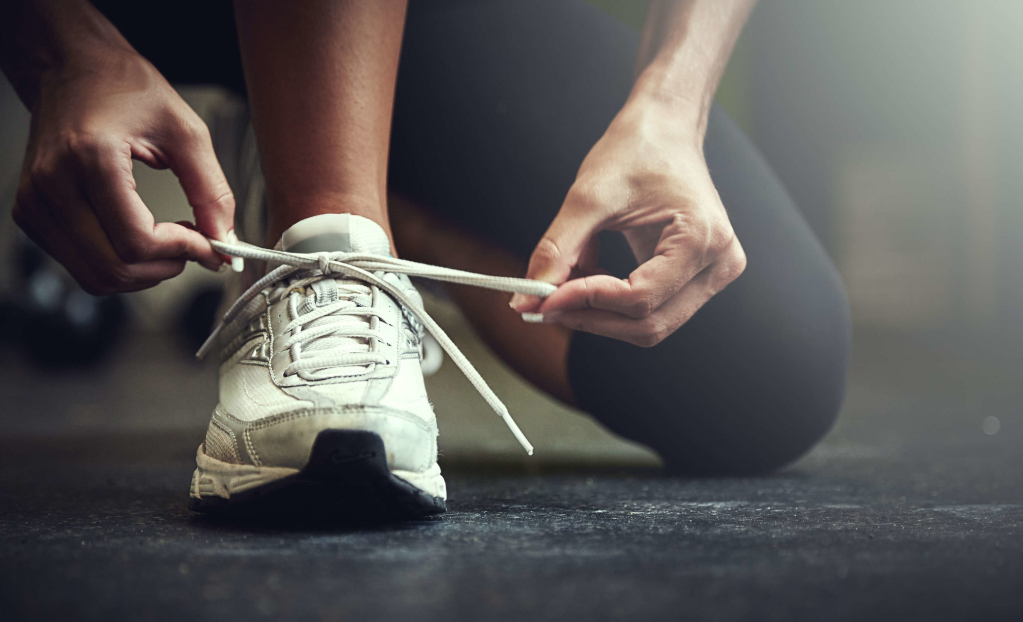 person tying a tennis shoe string