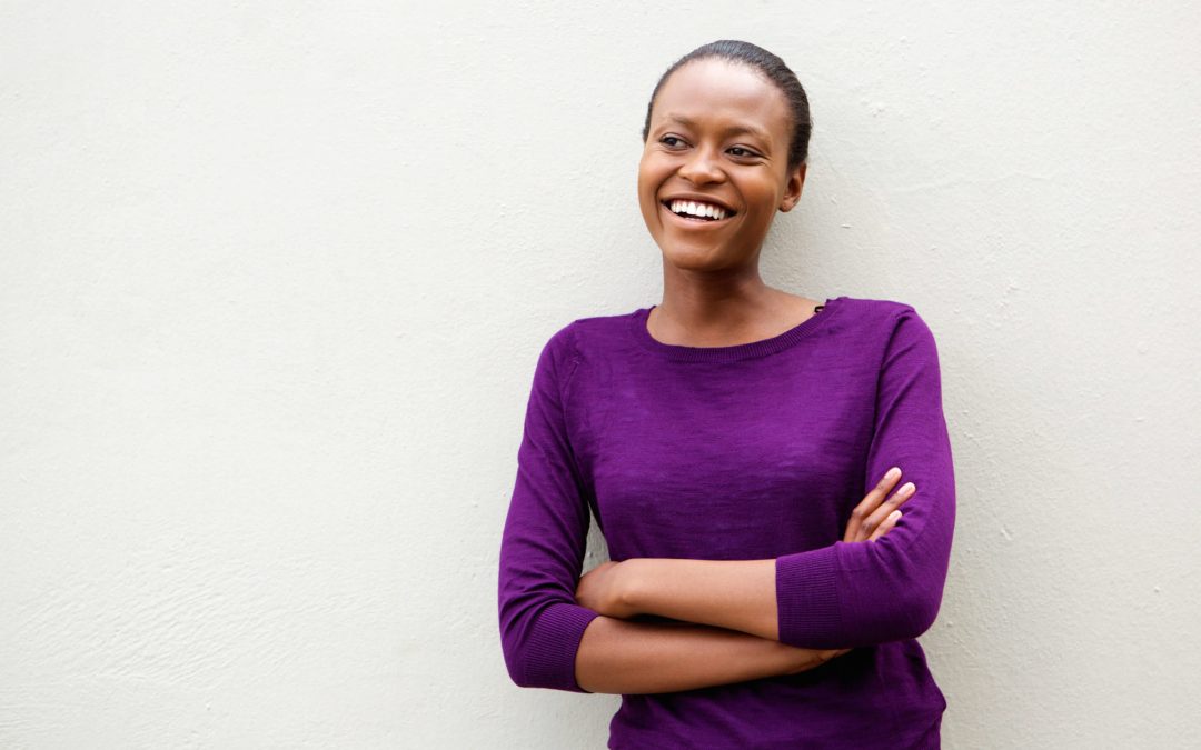 young woman leaning up against wall looking off to the side