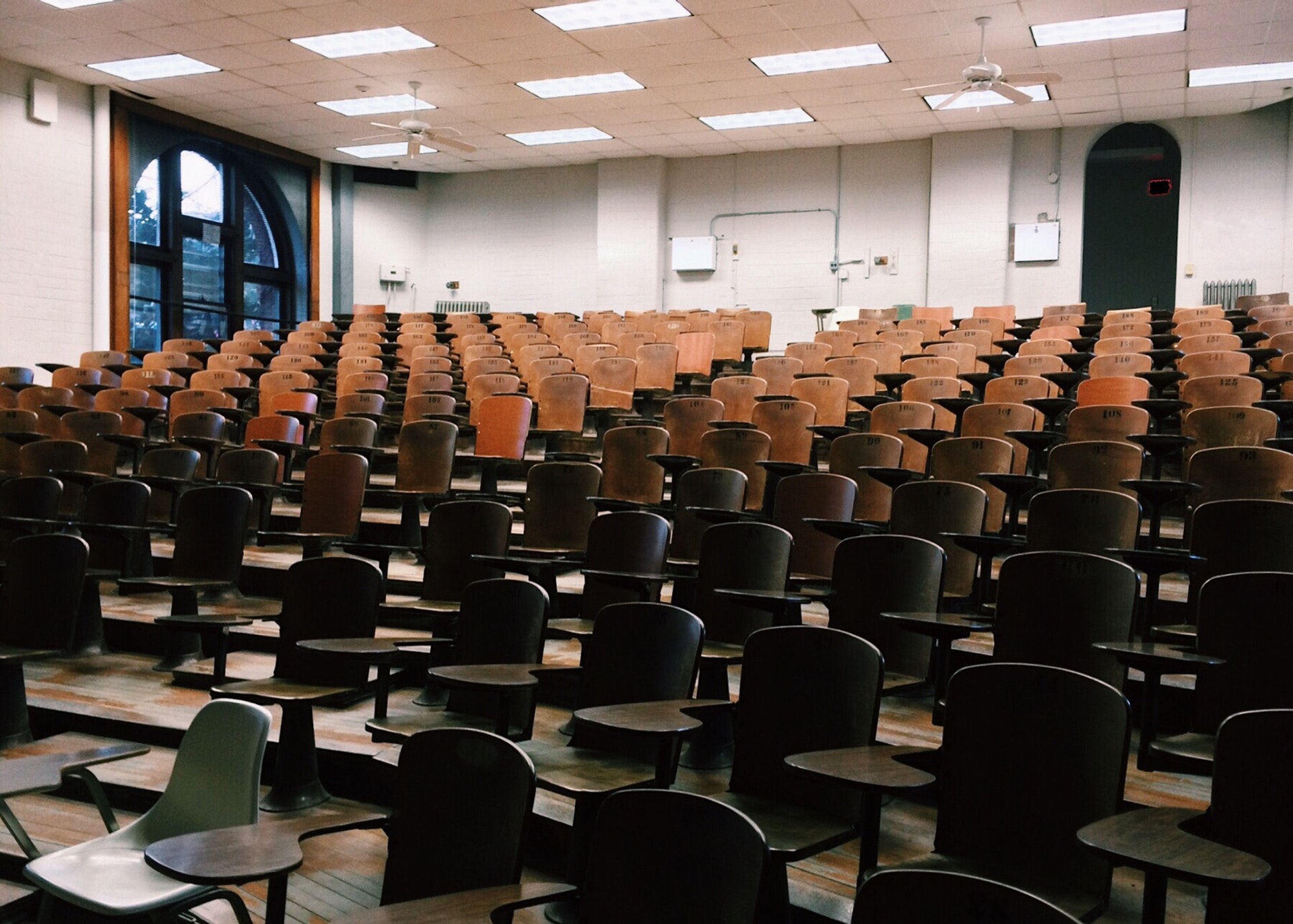 empty lecture hall with wooden desks